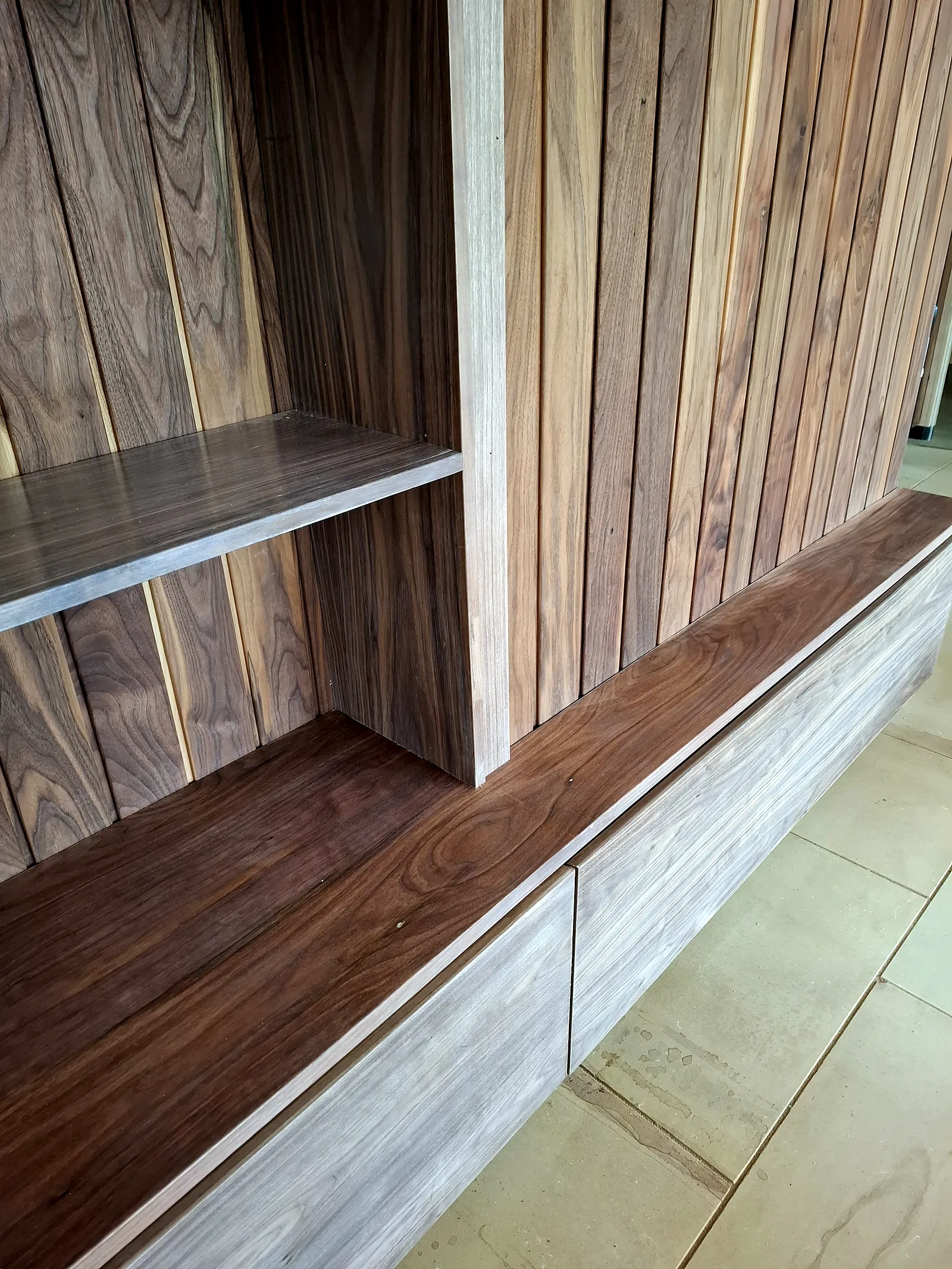 Close-up of walnut shelving, worktop and drawer fronts