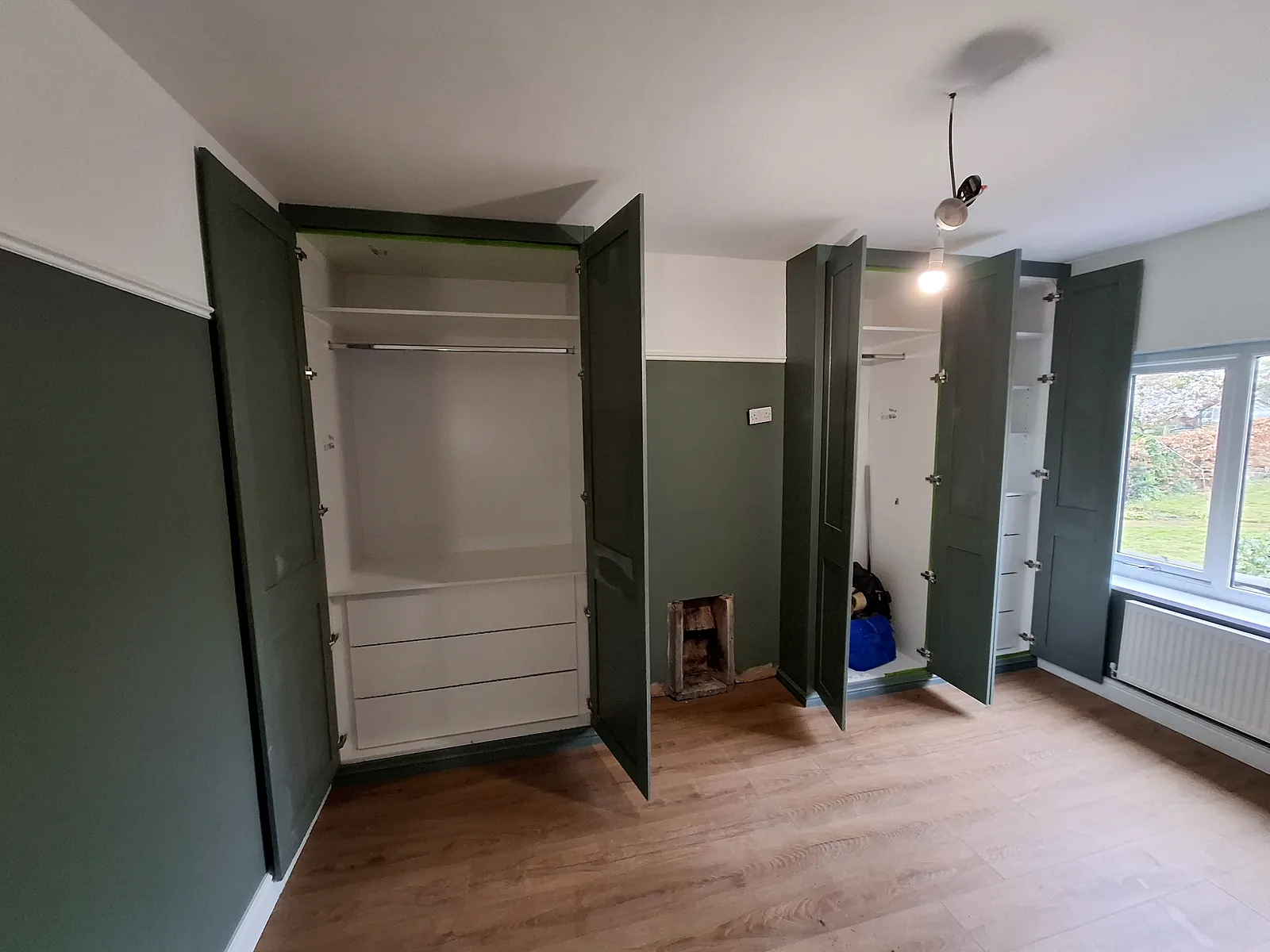 Fitted wardrobes with doors open showing hanging rails, shelves and drawers