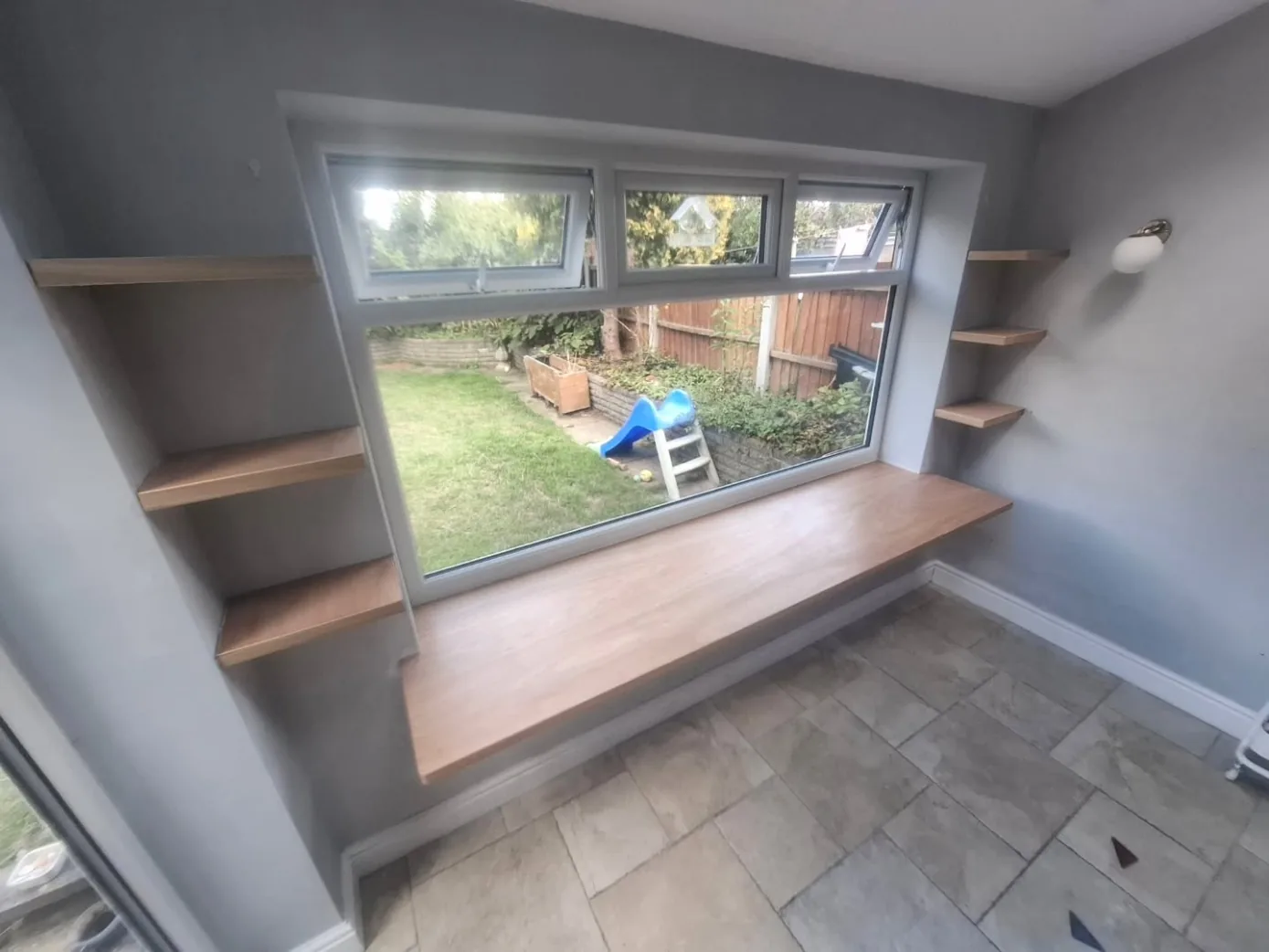 Floating hardwood window desk with shelves either side