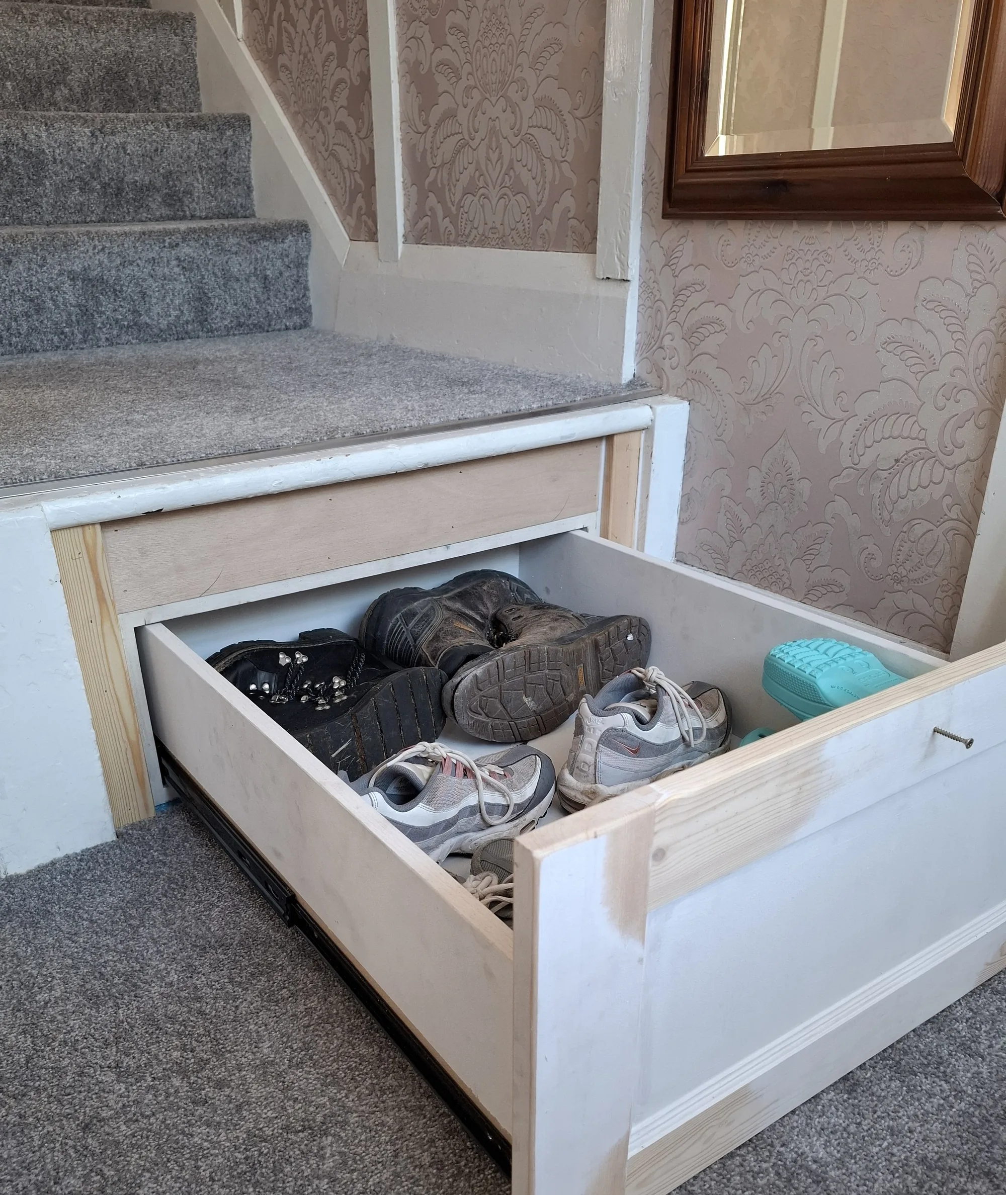 Pull-out shoe drawer built into the bottom stair
