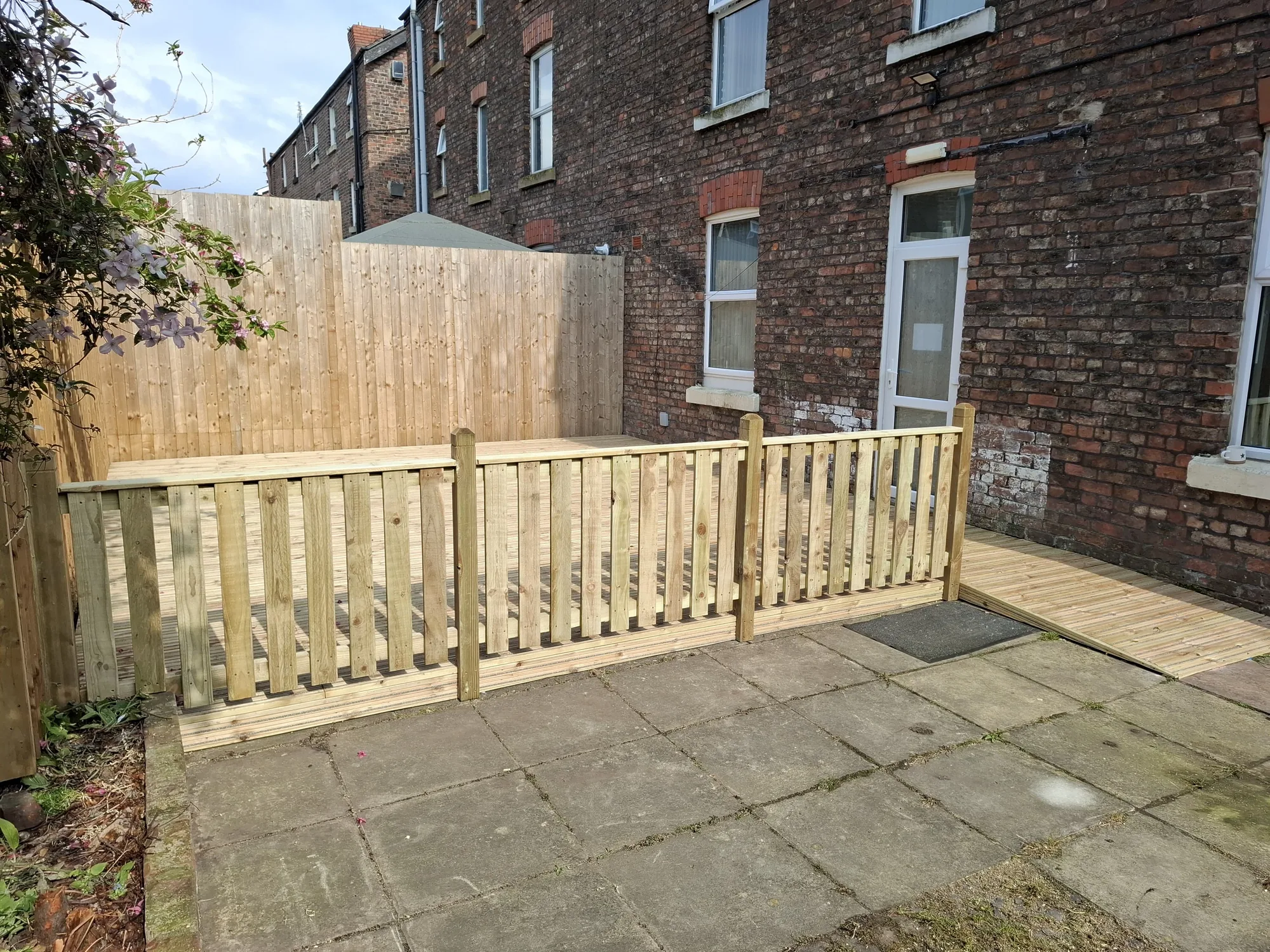Picket fence and decking walkway beside a terraced house