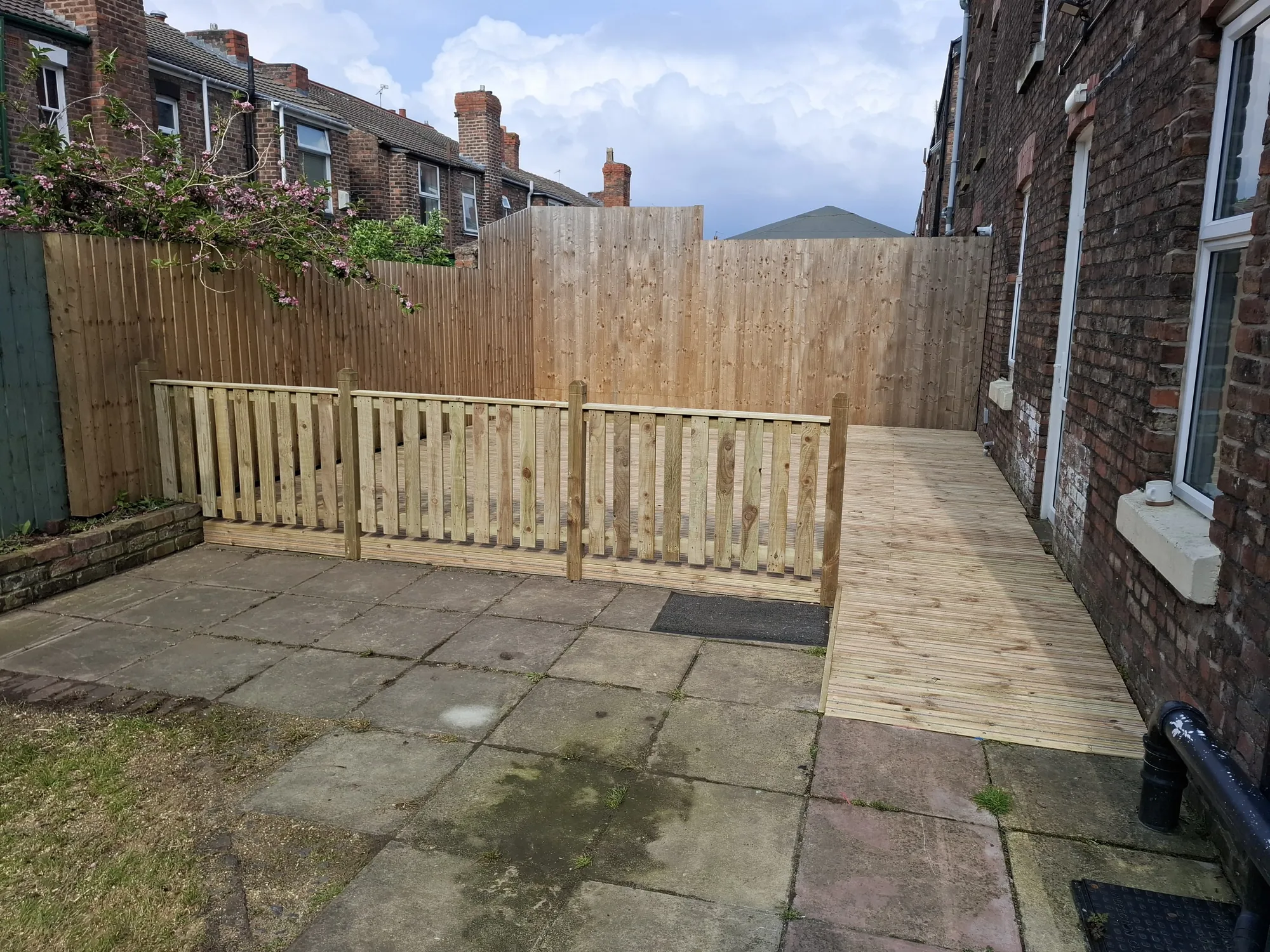 Picket fencing across the garden with decking behind