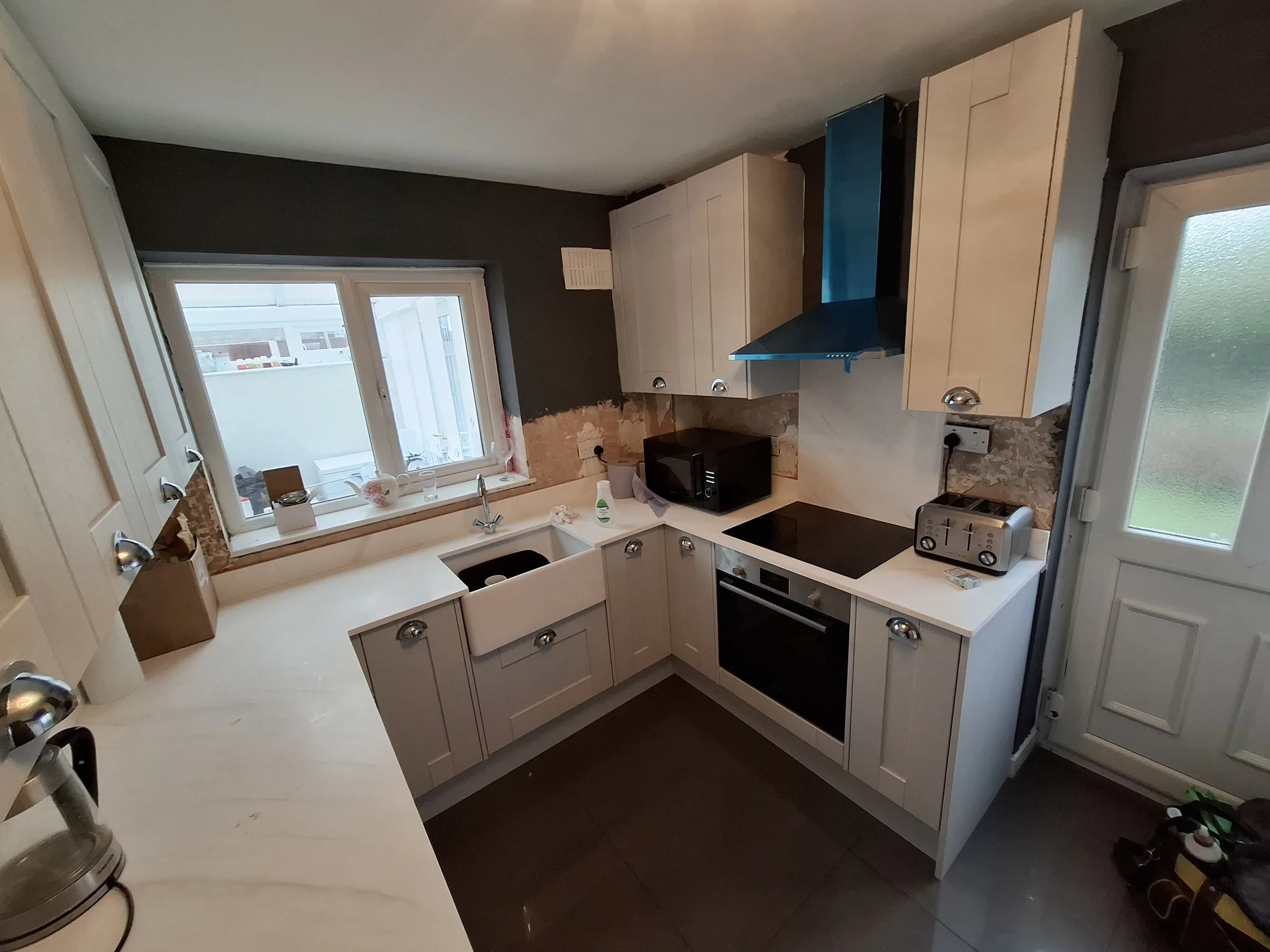 Grey shaker kitchen with a Belfast sink and chimney extractor