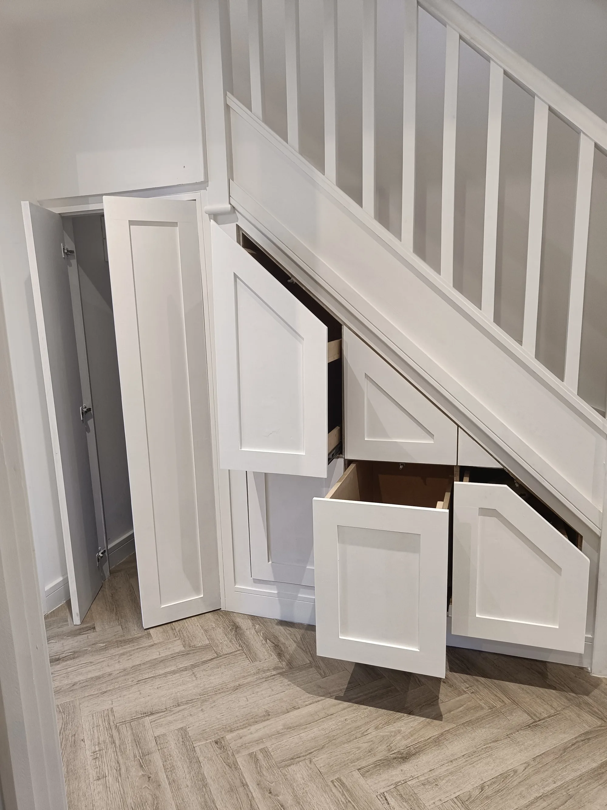 White under-stairs cupboards and pull-out drawers